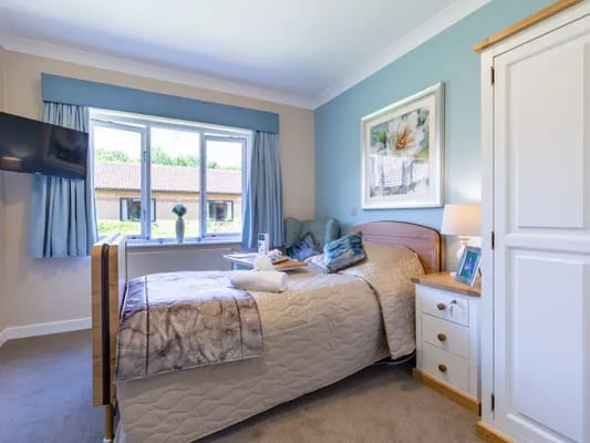 Bright interior of a resident's room with a bed and decor