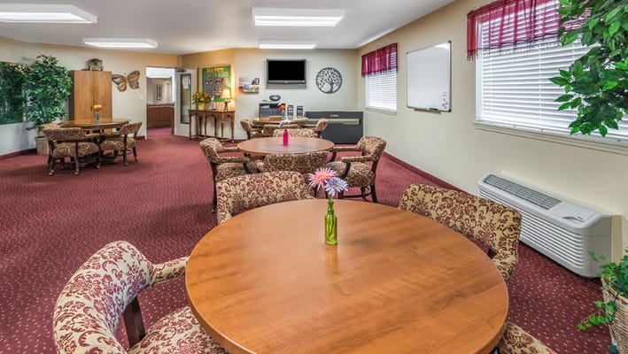 Common area with tables and chairs in a warm setting