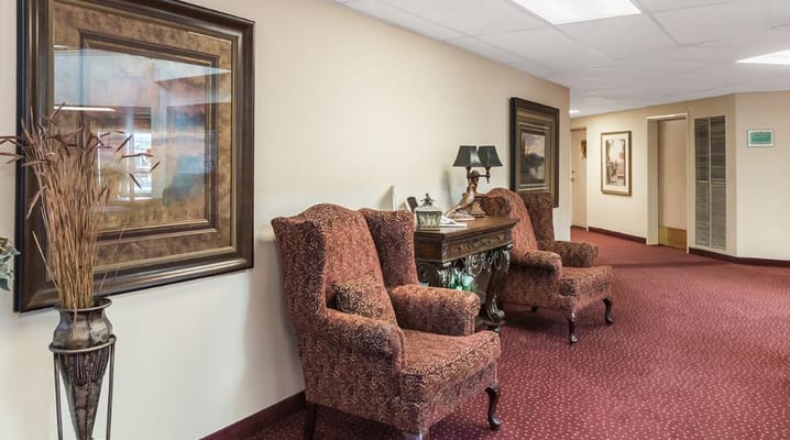 Interior hallway with decorative chairs and framed artwork