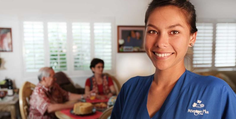 Staff member smiling in a lively common area with residents