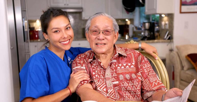 A caregiver and senior resident smiling together