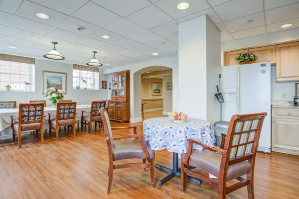 Dining area with a table and chairs, and a view of cabinets and kitchen appliances