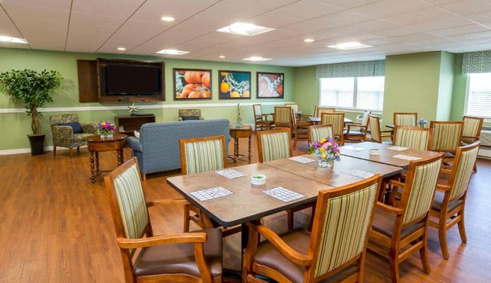Bright common area with dining tables and chairs.