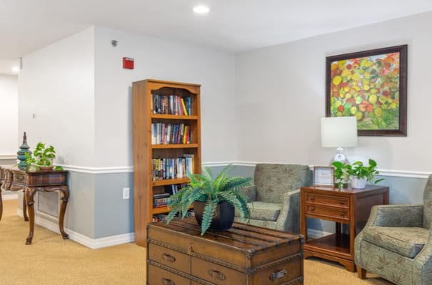 A cozy interior common area with seating and a bookshelf