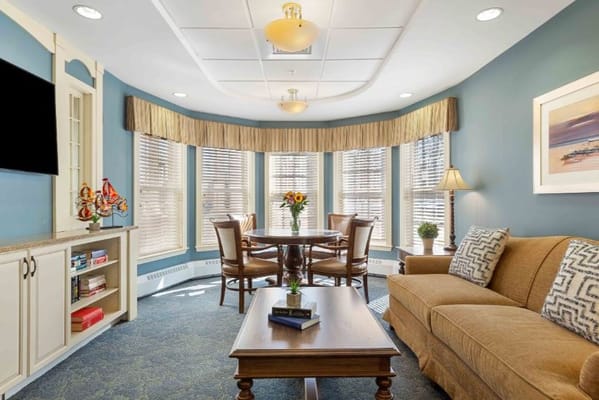 Cozy living room with seating and dining area, large windows, and decorative elements.