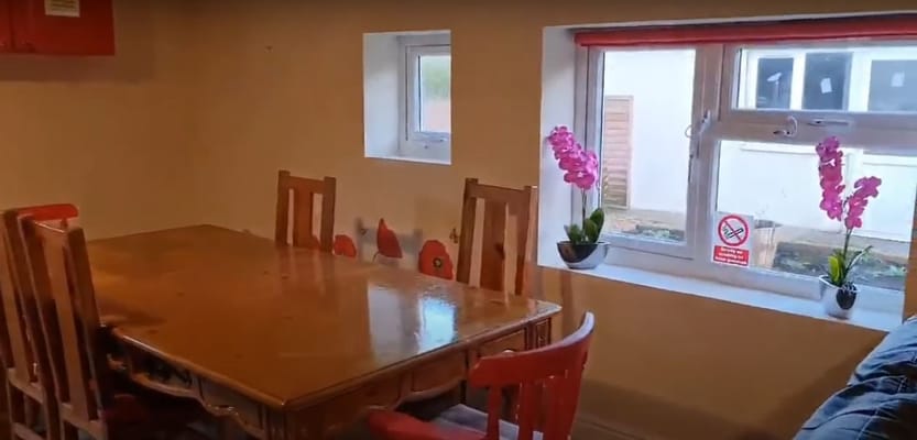A cozy dining area with a wooden table and flowers