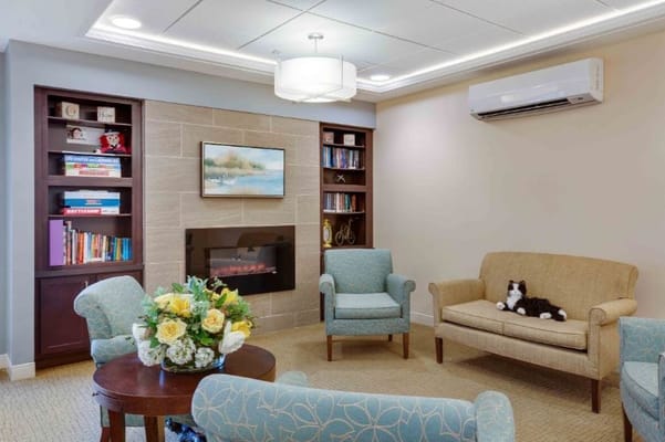 Inviting living room with seating and bookshelf in The Branches of North Attleboro.