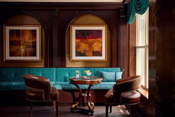Cozy lounge with teal seating and artwork on the walls