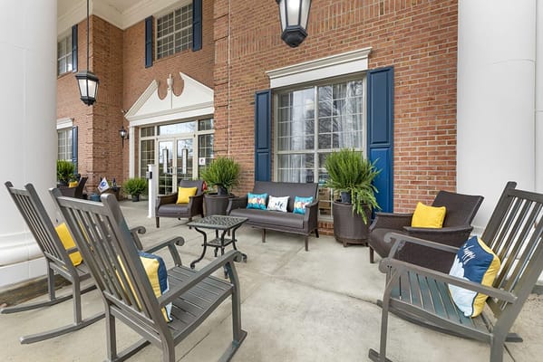 Outdoor seating area with rocking chairs and potted plants