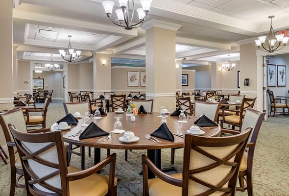Dining room setup with tables and chairs for residents