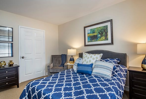Cozy bedroom with decorative bedding and seating area