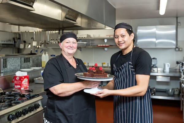 Kitchen staff presenting a chocolate cake