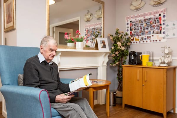 Resident reading in a cozy lounge area