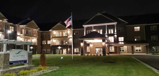 Exterior view of Calumet Trace at night with flags