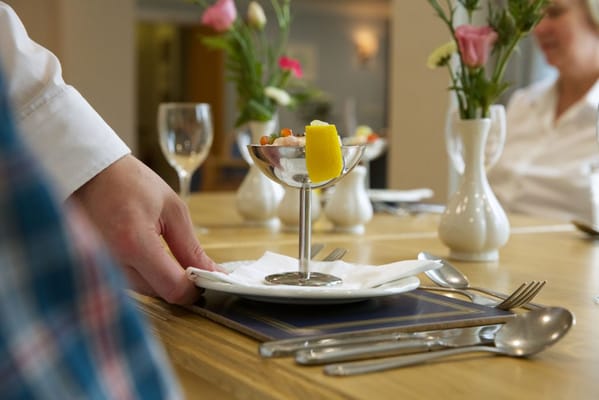 Dining table with gourmet food and flowers in a dining room