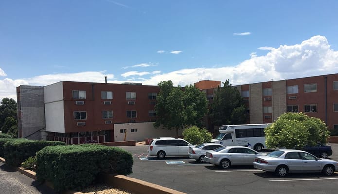 Exterior view of Camino Retirement Apartments with parking.