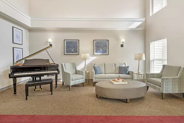 Bright and inviting common area with a piano and seating