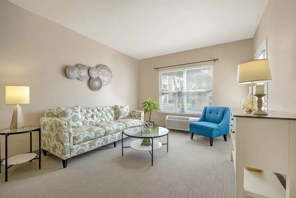 Bright living room with floral couch and blue chair