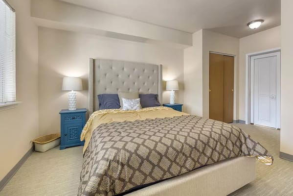 Well-decorated private resident room with a bed and lighting