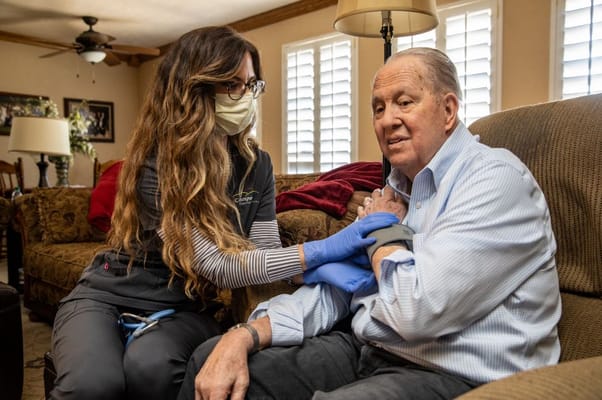 Healthcare worker assisting a senior man at home