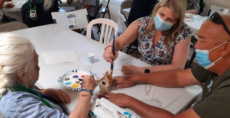Residents and staff engaged in a craft activity indoors