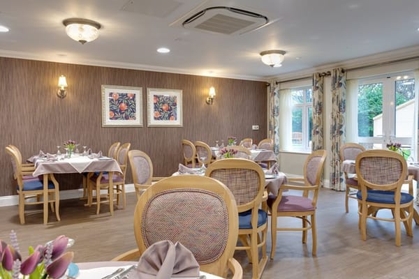 Dining room set for a meal with floral arrangements