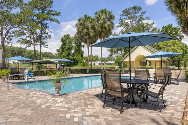 Outdoor pool area with seating and umbrellas