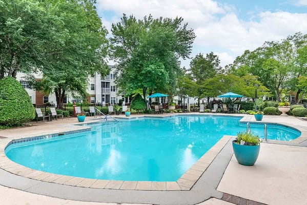 Outdoor pool area with lounge chairs and umbrellas