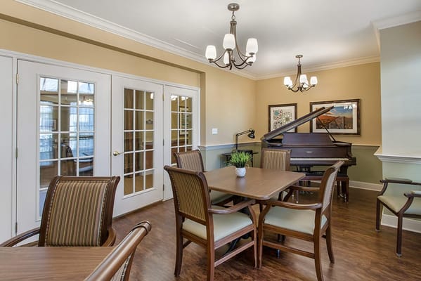 Bright common area with piano and dining tables