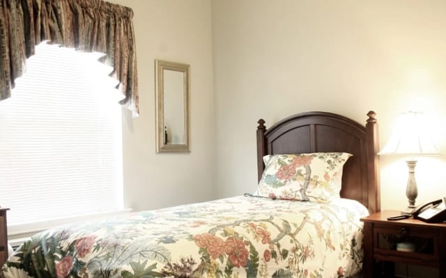 Cozy bedroom setup with floral bedding and natural lighting