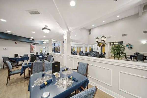 Spacious dining area with blue tables and floral decor