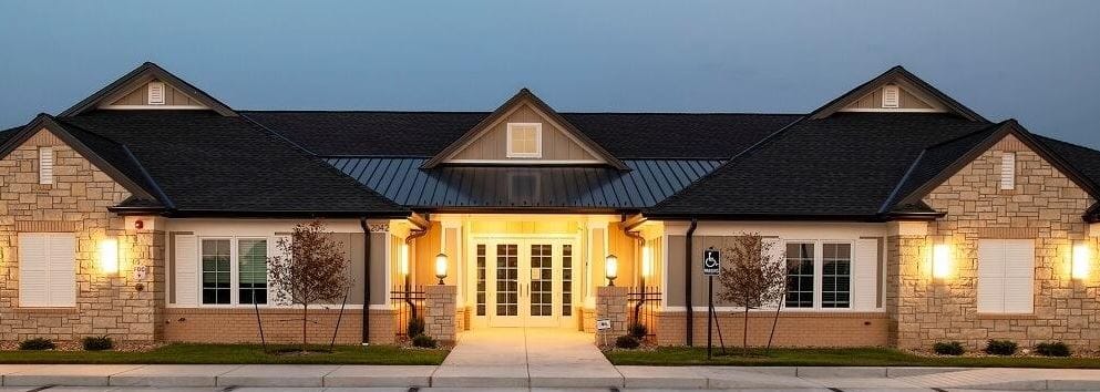 Exterior view of a senior care facility building at dusk