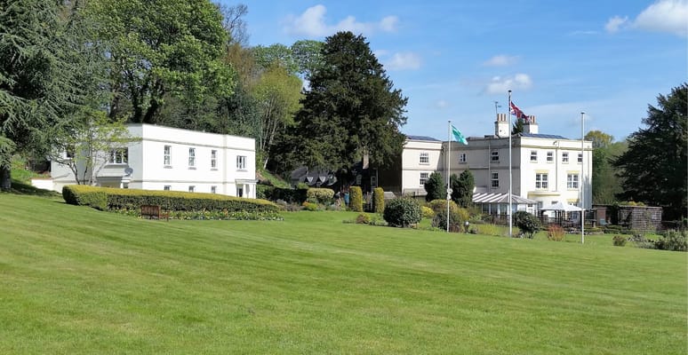 Exterior view of Coxbench Hall with landscaped gardens
