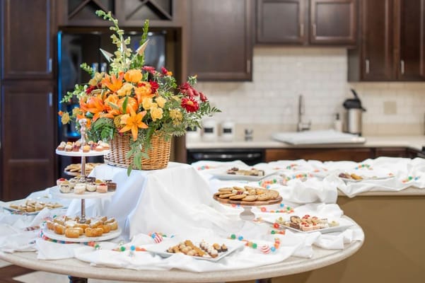 A beautifully arranged table with desserts and floral centerpiece