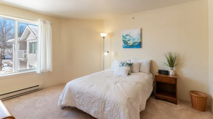 Well-lit bedroom in a senior living facility with a cozy atmosphere