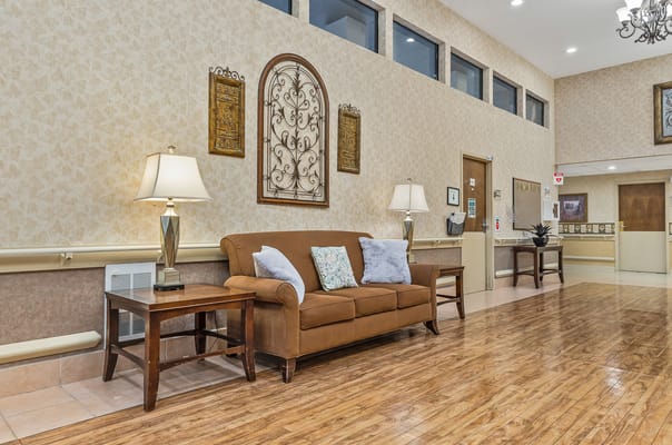 Cozy brown sofa with pillows in a well-lit lobby area
