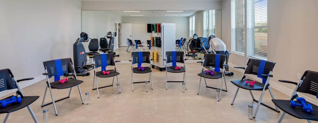 Activity room with exercise equipment and chairs arranged for group sessions