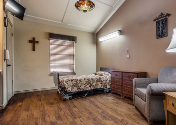 A well-furnished resident room with a bed and seating area