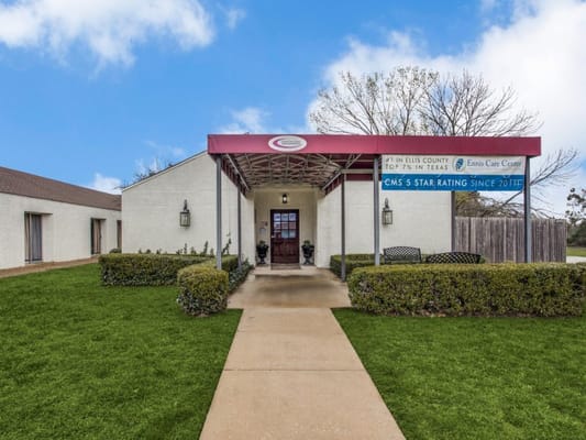 Front entrance of Ennis Care Center with landscaped area
