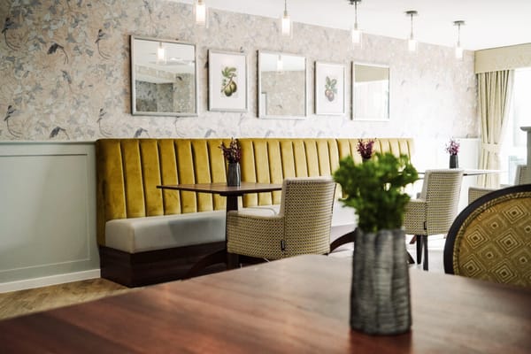 Dining area with yellow seating and floral decor