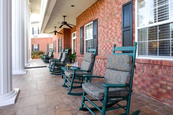 Outdoor seating area with rocking chairs in a senior living facility