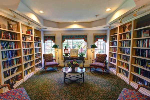 A cozy library corner with bookshelves and seating at The Forum at Deer Creek.