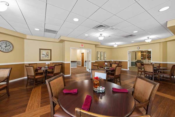 Brightly lit dining room with wooden tables and chairs