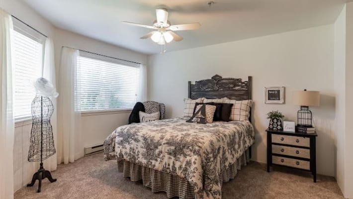 Well-furnished bedroom with a bed, chair, and decorative accents.