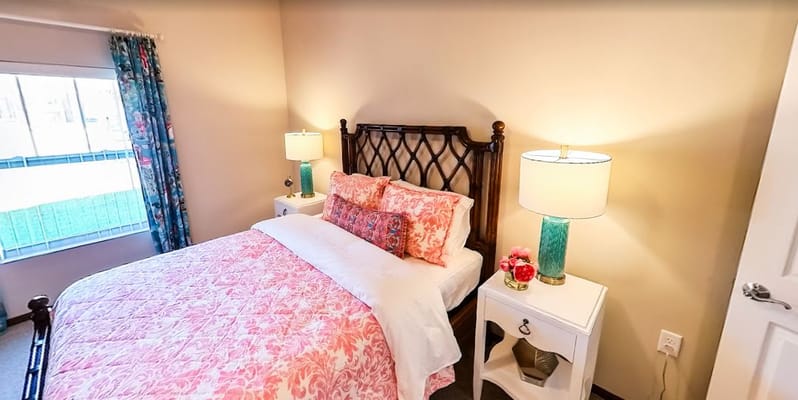 Comfortable bedroom with floral bedding and stylish lamps