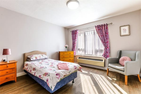 Comfortable bedroom with a floral bedspread and natural light