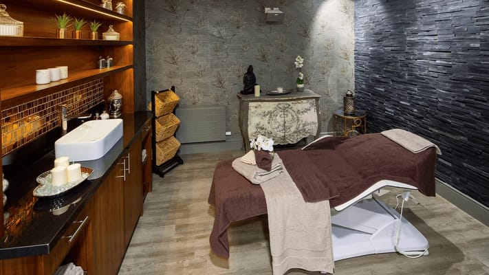 Spa treatment room with massage table and decor