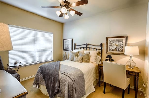 A well-decorated private resident room with a bed and desk