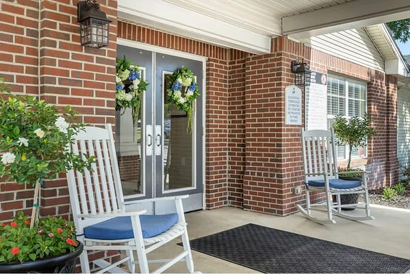 Welcoming entrance with rocking chairs and flower decorations