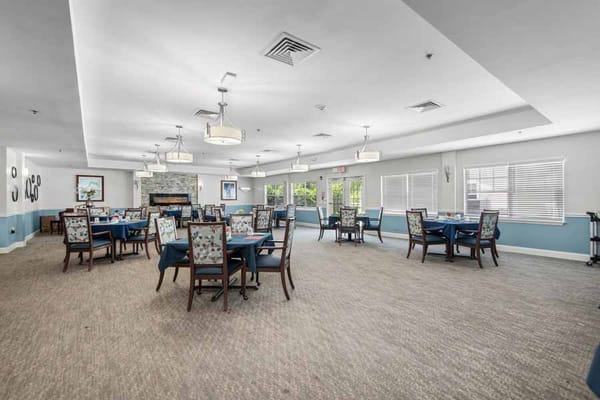 Bright dining room with tables and chairs in Home Place of New Bern